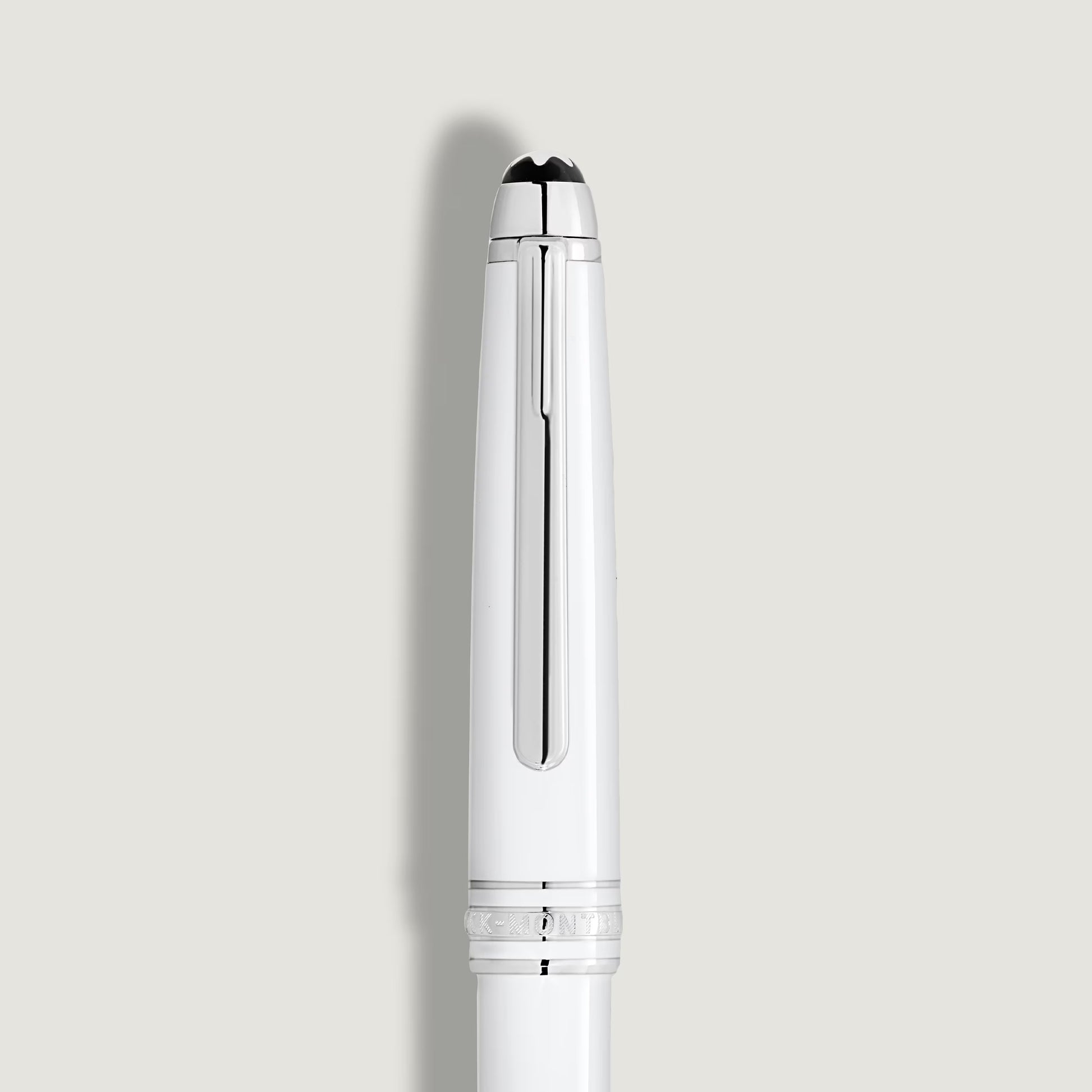 Close-up of the white resin cap featuring the iconic Montblanc emblem and platinum clip, showcased by Salam Luxury.