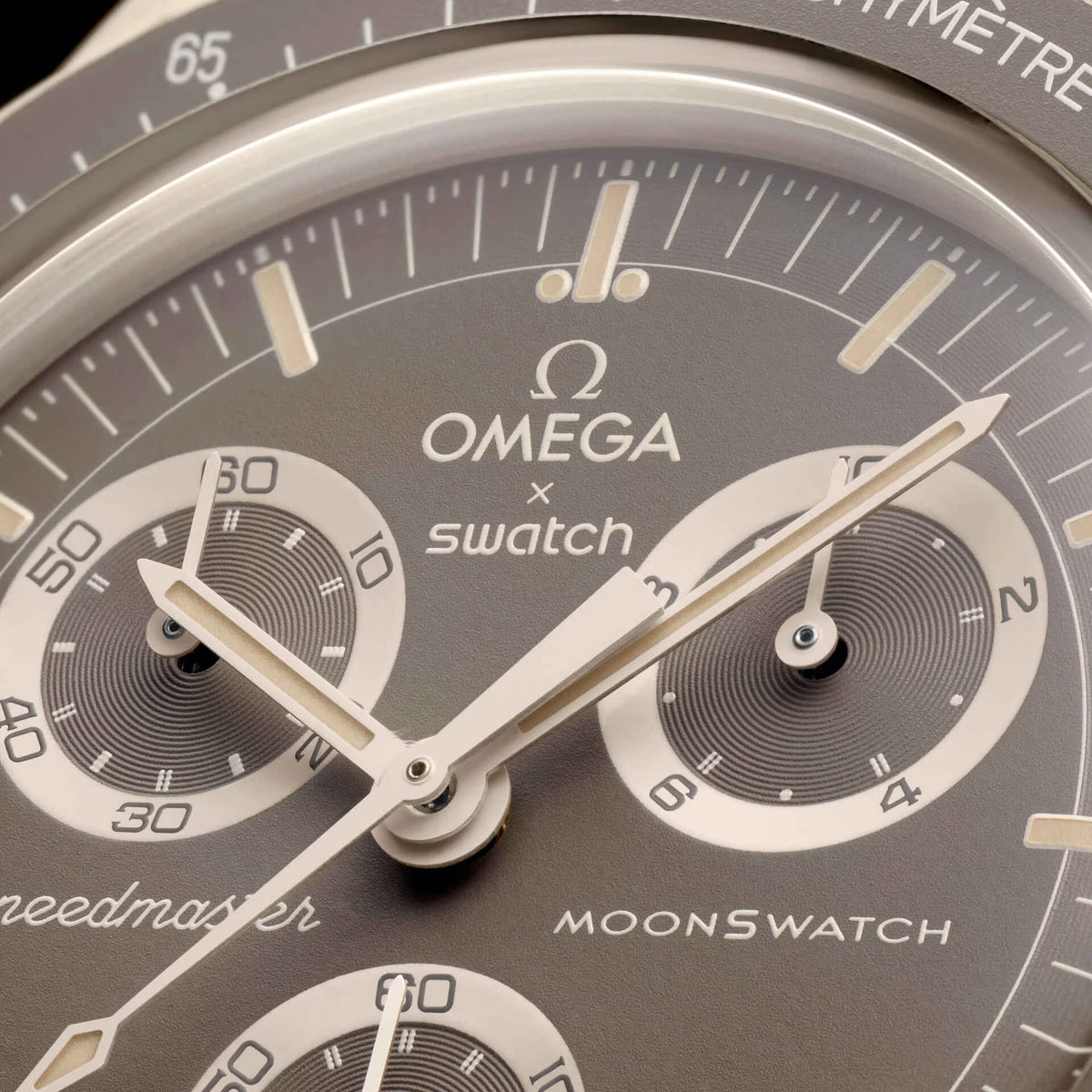 Desert | Detailed close-up of the beige dial and hands with Omega and Swatch logos - SALAM LUXURY