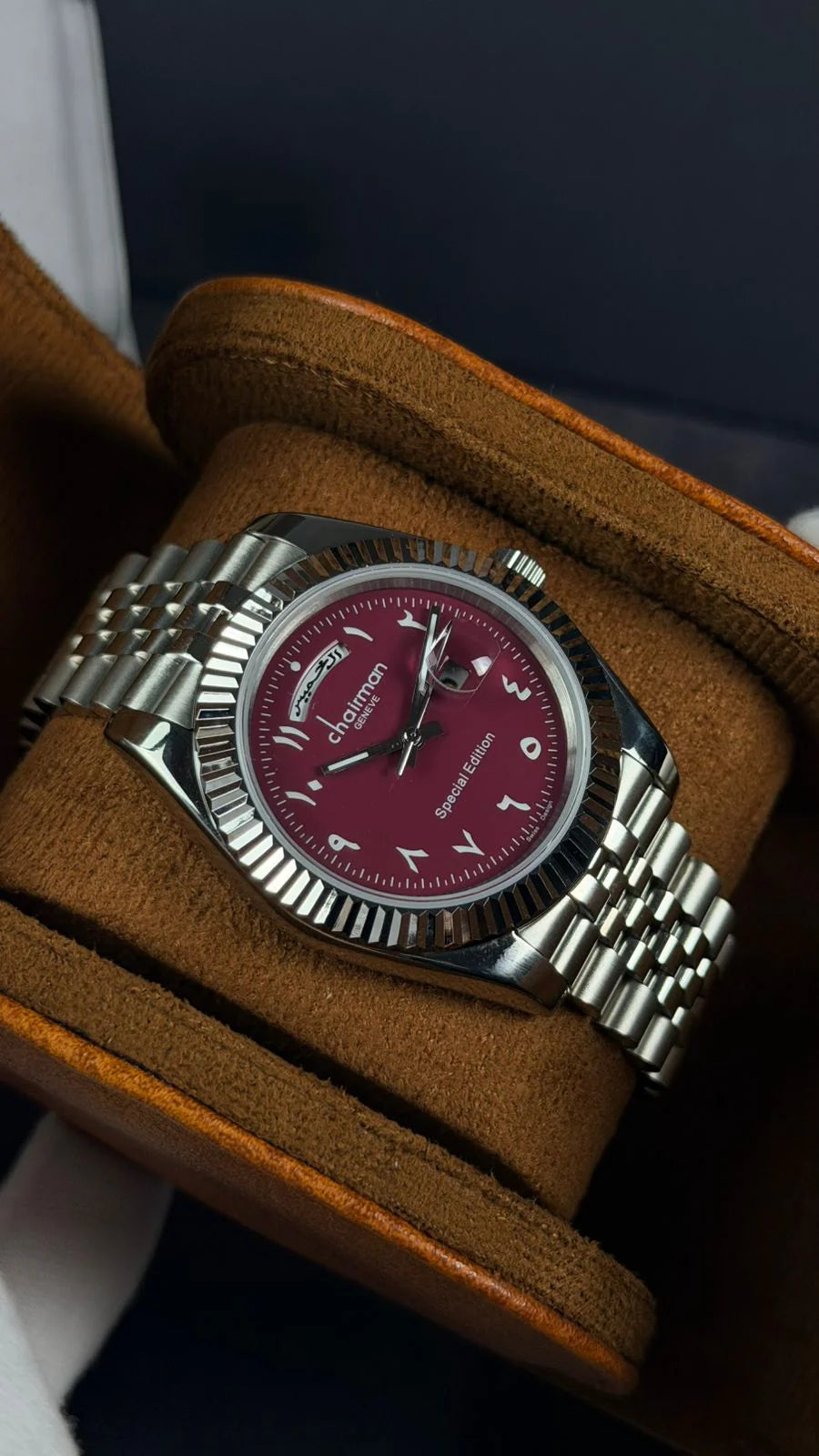 Watch with a red face and silver case on a brown cushion
Salam Luxury UAE