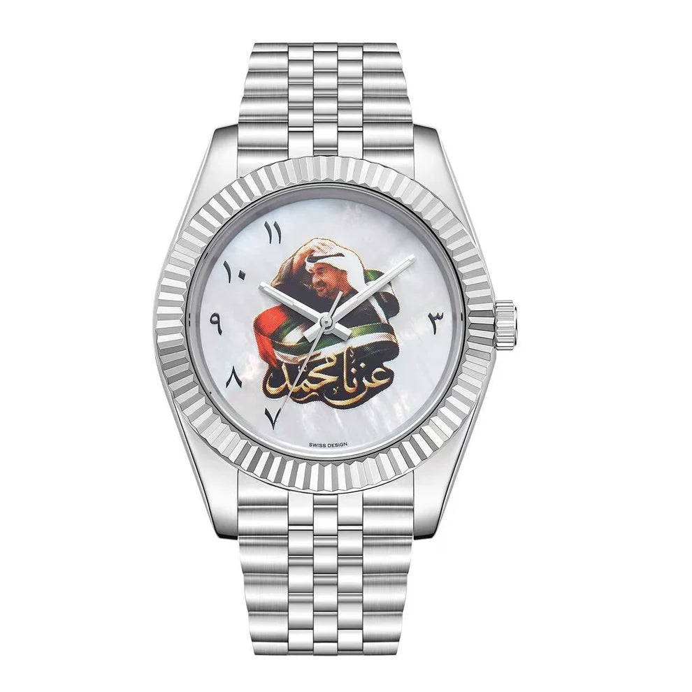 A silver-tone metal wristwatch with a fluted bezel, silver link bracelet, and a white dial featuring a printed portrait of a man in a white cap and Arabic calligraphy.
Salam Luxury UAE