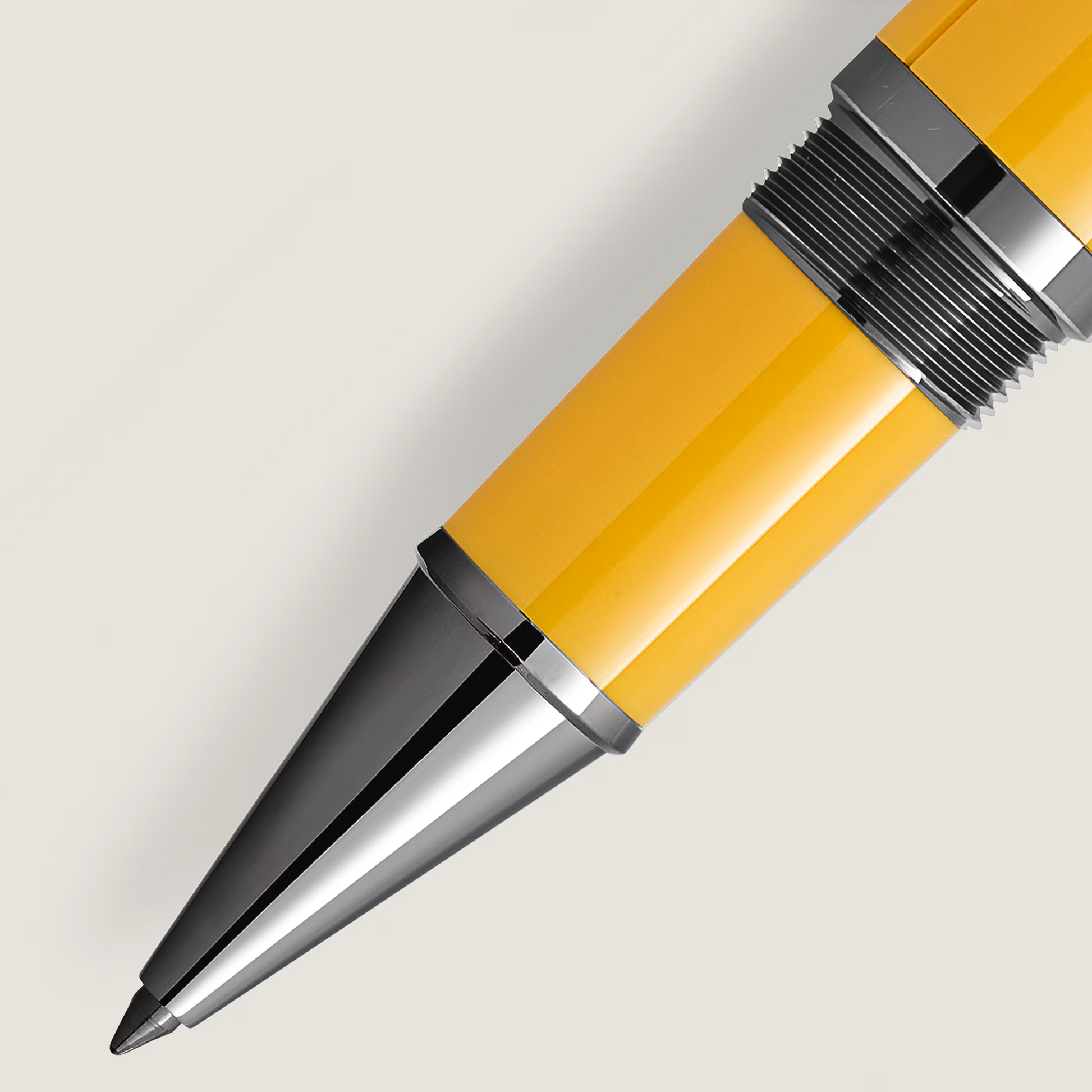 Close-up of the polished metal front section, threading, and vibrant Giallo Modena yellow barrel of the Montblanc Enzo Ferrari rollerball pen from Salam Luxury