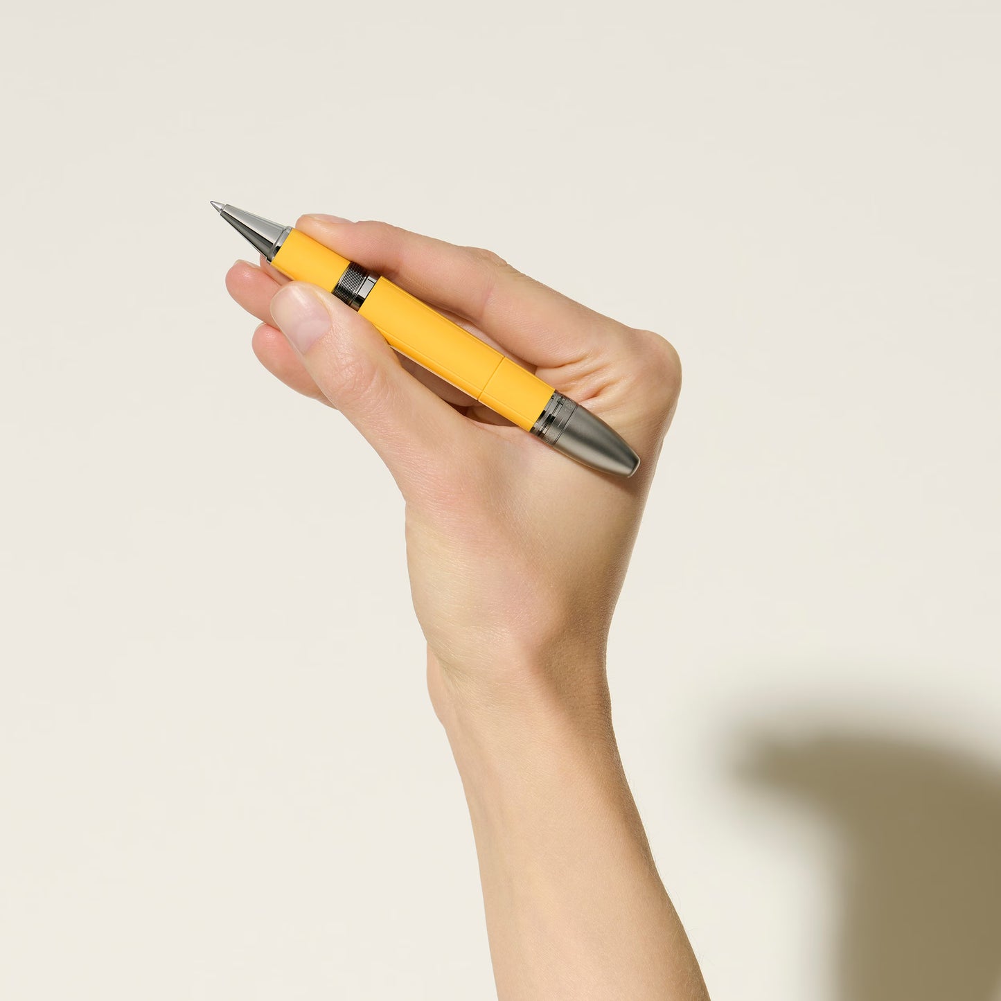 Premium racing-inspired yellow Montblanc Enzo Ferrari rollerball pen held in hand for a professional lifestyle shot, online at Salam Luxury.