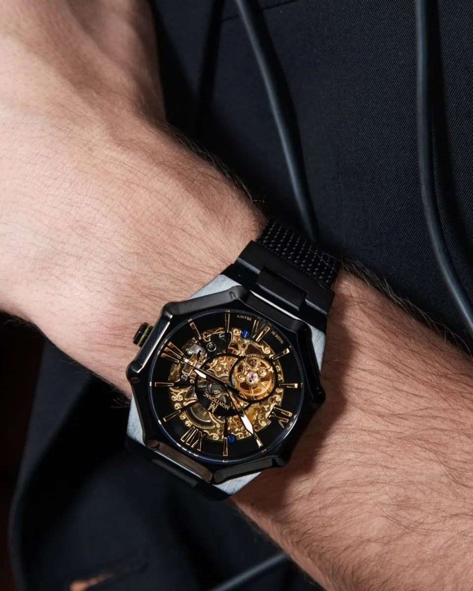 Close-up of a wrist wearing a black and gold watch with a detailed mechanism.
Salam Luxury