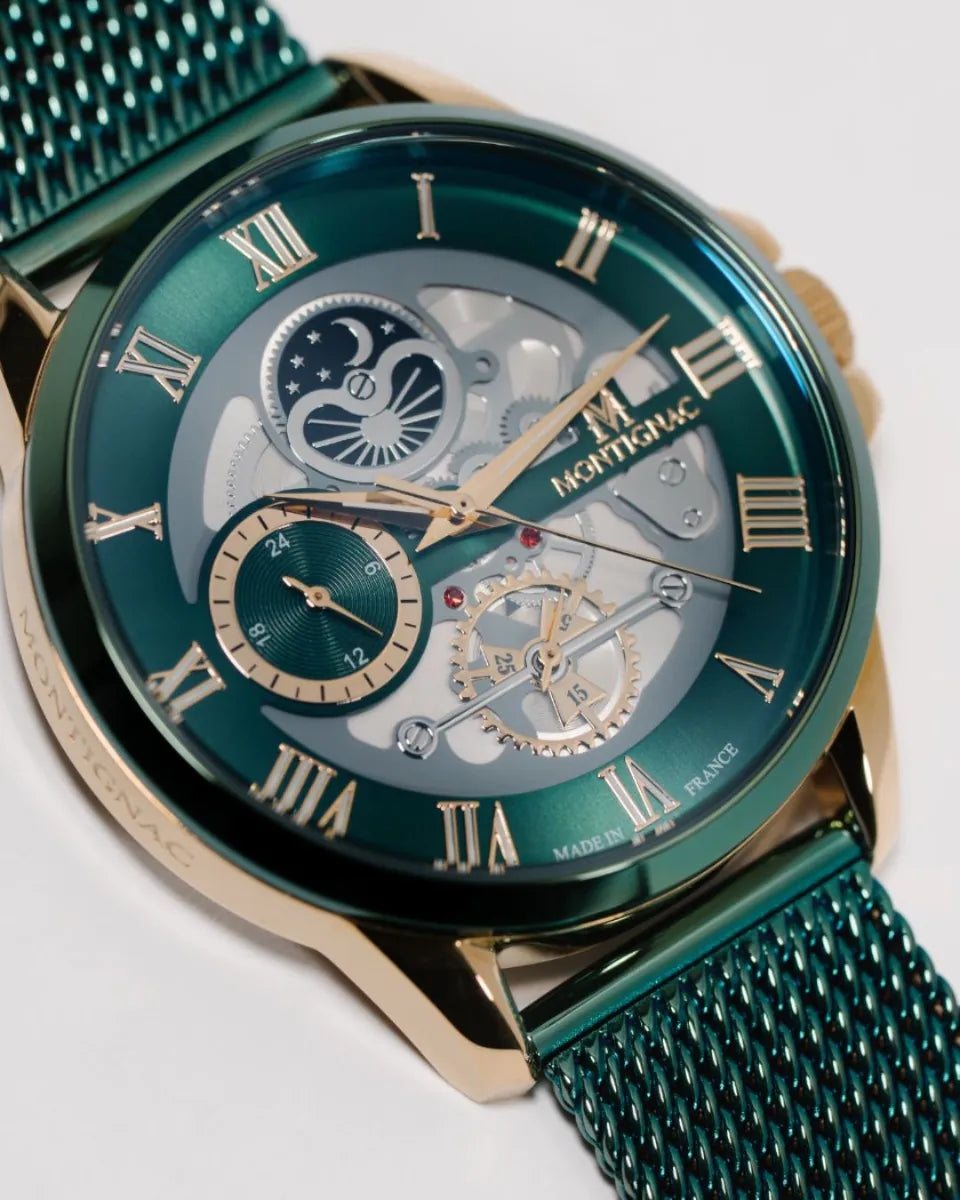 Green | wristwatch with detailed face and mesh band on a white background