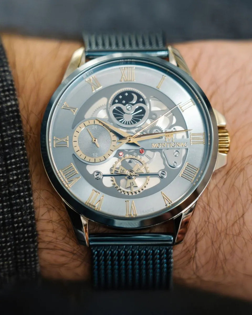 Light Blue | Luxury watch with detailed face and blue mesh band on a wrist.