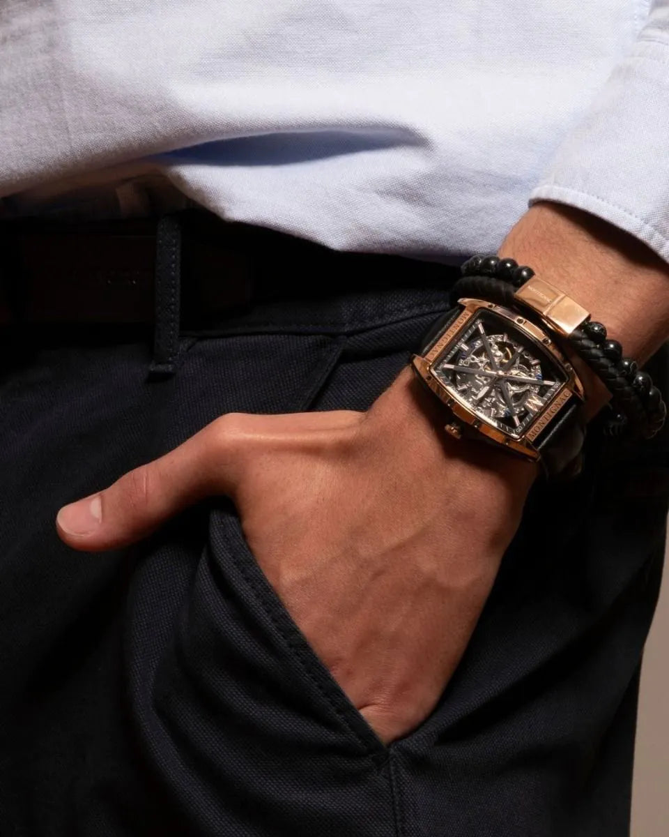 Close-up of a hand wearing a detailed wristwatch with a textured strap.