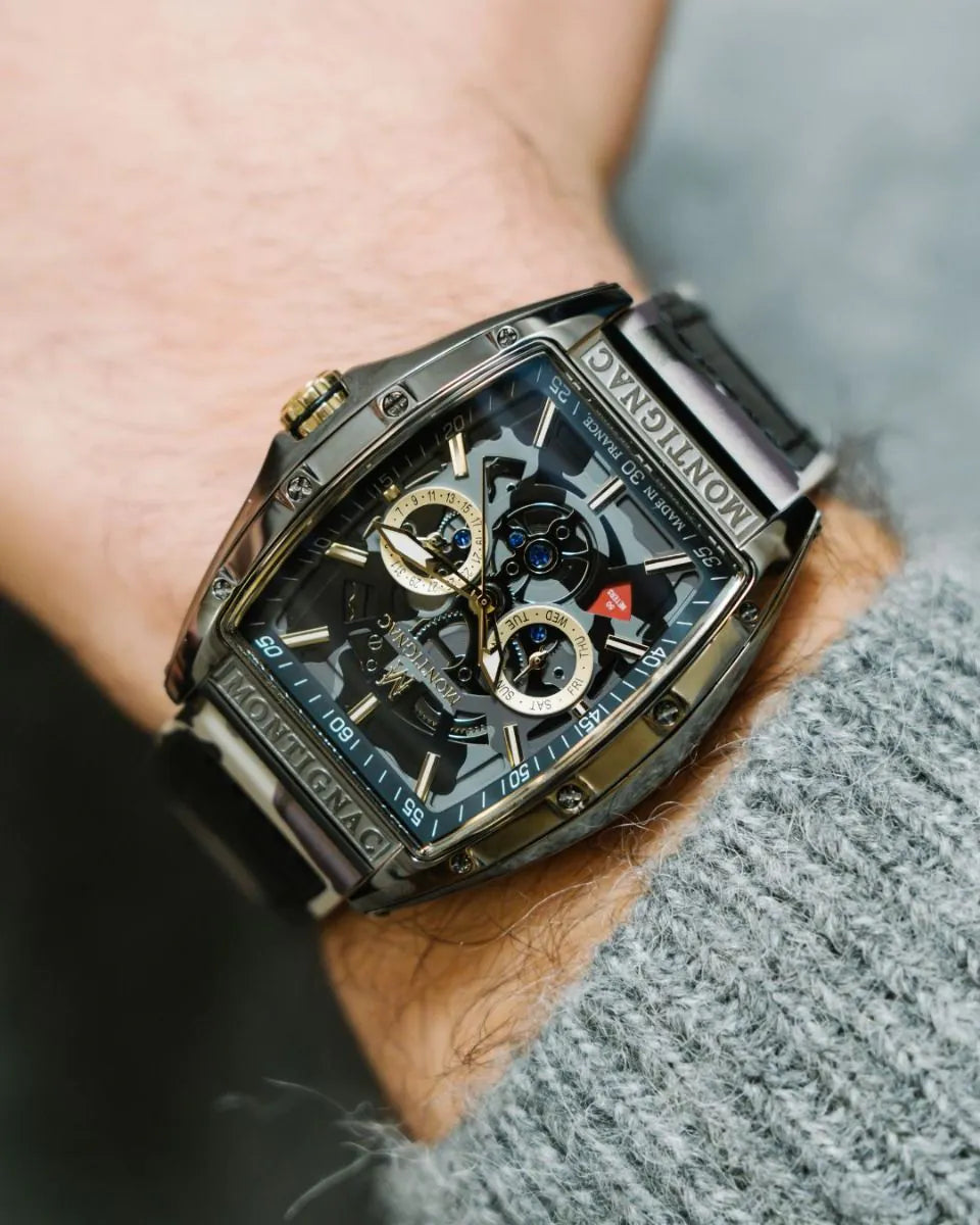Close-up of a person's wrist wearing a detailed watch with a blurred background