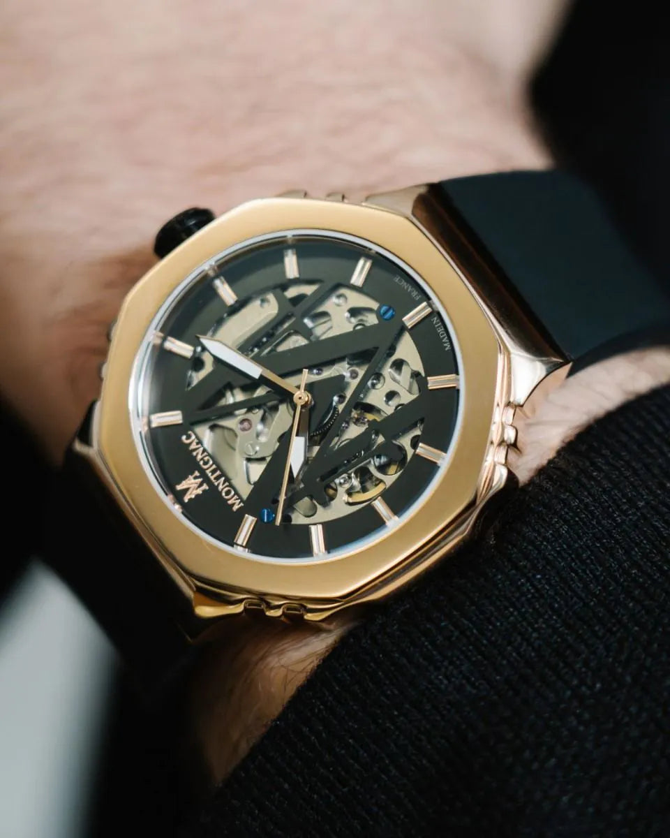 Gold wristwatch with a black face on a person's wrist