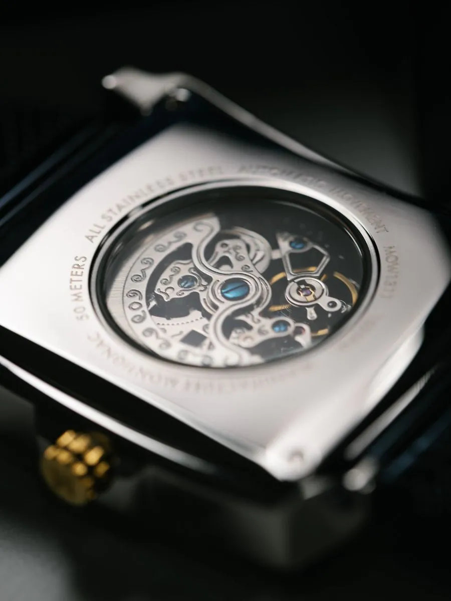 Close-up of a mechanical watch with intricate details on a dark
background
Salam Luxury