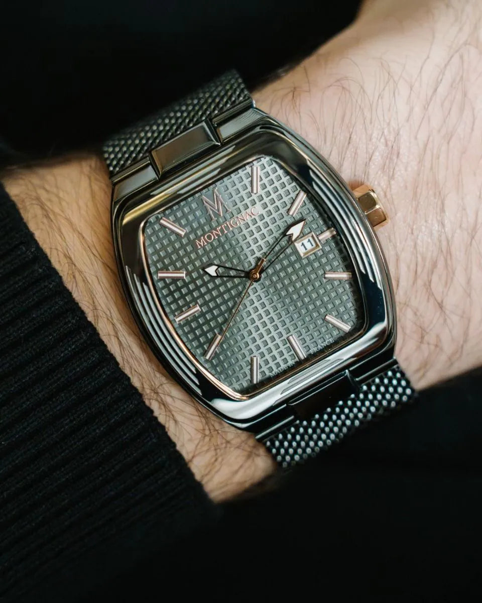 Montblanc watch on a wrist with a textured face and black mesh band.