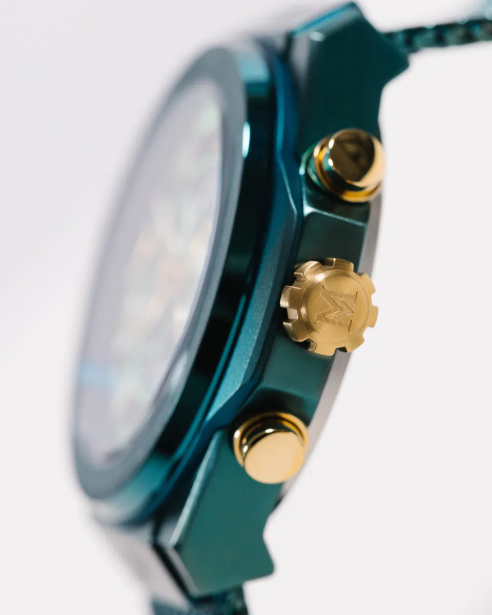 Green | Close-up of a teal watch with gold accents on a white background
Salam Luxury