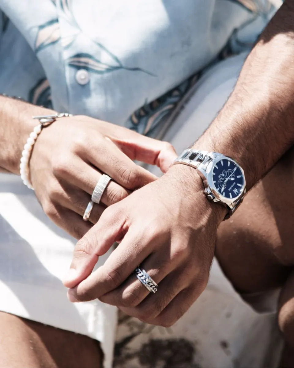 Close-up of hands with jewelry, including a watch, rings, and bracelets.
Salam Luxury